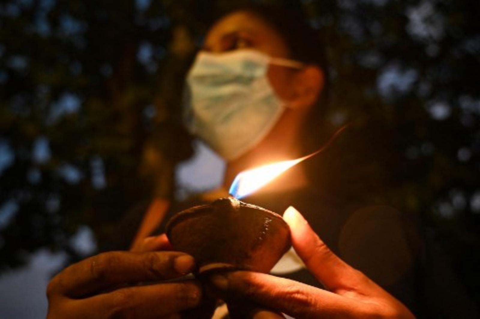A protestor holds an oil lamp during a demonstration against the surge in prices and shortage of fuel and other essential commodities.